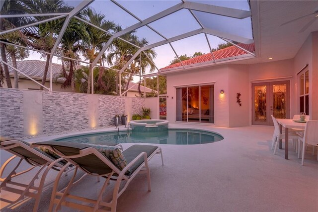 pool at dusk featuring french doors, a patio area, glass enclosure, and an in ground hot tub