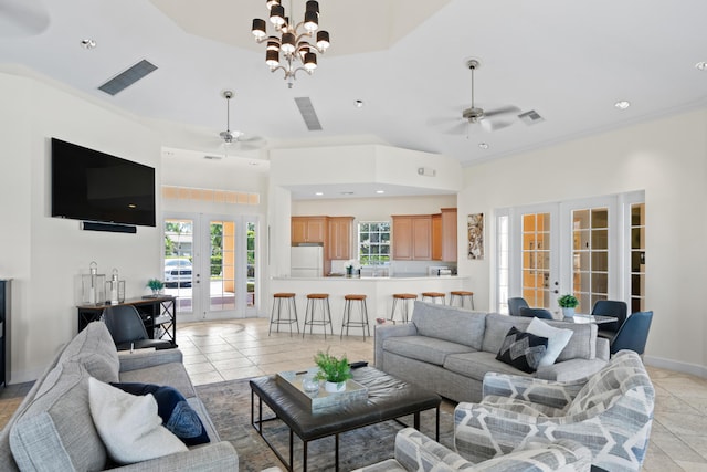 tiled living room with ceiling fan with notable chandelier and french doors