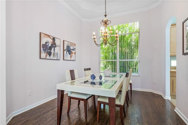 dining space with dark wood-type flooring, ornamental molding, and a chandelier