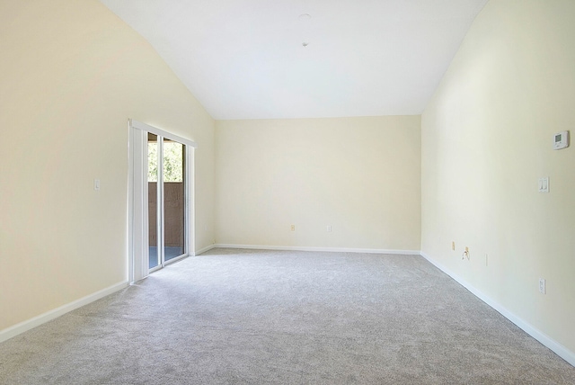 carpeted spare room featuring vaulted ceiling