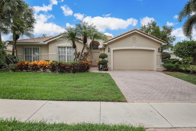 view of front of property with a front yard and a garage