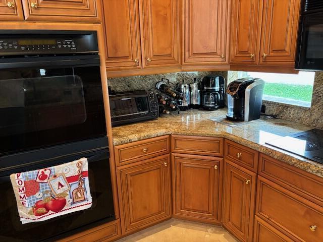 11420 Ohanu Cir, Boynton Beach, FL 33437 - kitchen with black appliances, tasteful backsplash, and brown cabinetry
