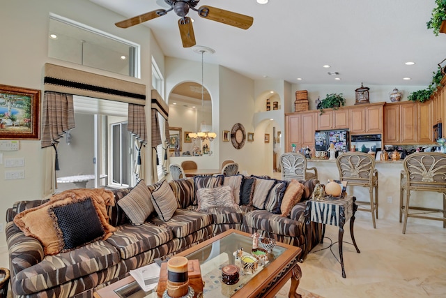 living room with ceiling fan and a high ceiling