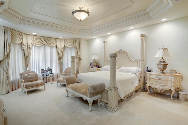 carpeted bedroom with a tray ceiling and crown molding