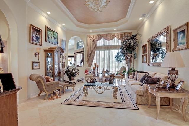 living room featuring a raised ceiling and ornamental molding