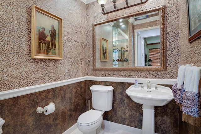 bathroom featuring ornamental molding and toilet