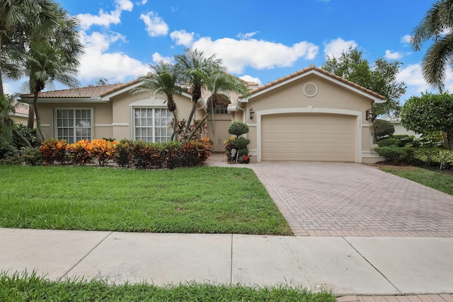 11420 Ohanu Cir, Boynton Beach, FL 33437 - view of front of home featuring decorative driveway, a garage, stucco siding, a front yard, and a tiled roof