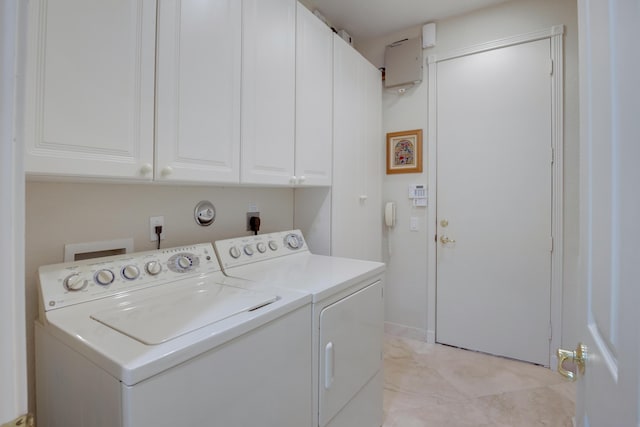 washroom featuring cabinets and washer and clothes dryer