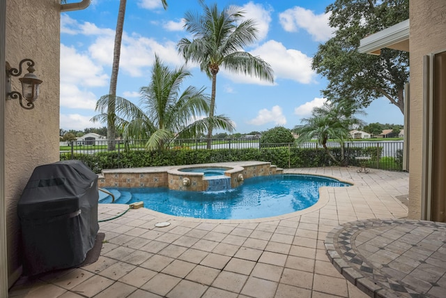 view of swimming pool featuring an in ground hot tub, pool water feature, a patio, and a grill