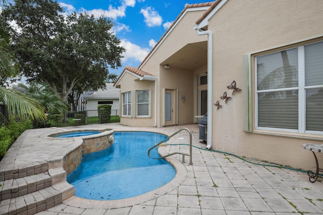 view of pool featuring a patio area and an in ground hot tub