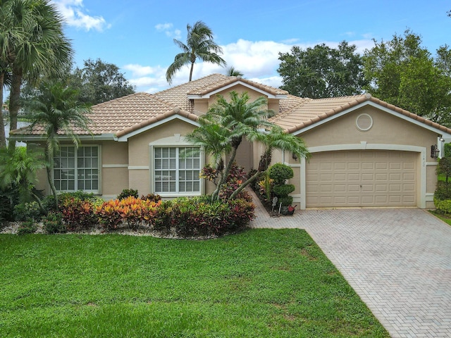11420 Ohanu Cir, Boynton Beach, FL 33437 - mediterranean / spanish house with an attached garage, decorative driveway, stucco siding, a front yard, and a tile roof