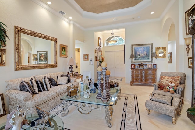 living room featuring a raised ceiling, ornamental molding, and a towering ceiling