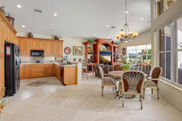 11420 Ohanu Cir, Boynton Beach, FL 33437 - kitchen with black appliances, light countertops, a peninsula, a chandelier, and open floor plan