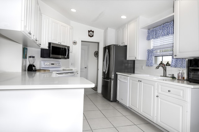 kitchen with sink, white appliances, light tile patterned floors, white cabinetry, and kitchen peninsula