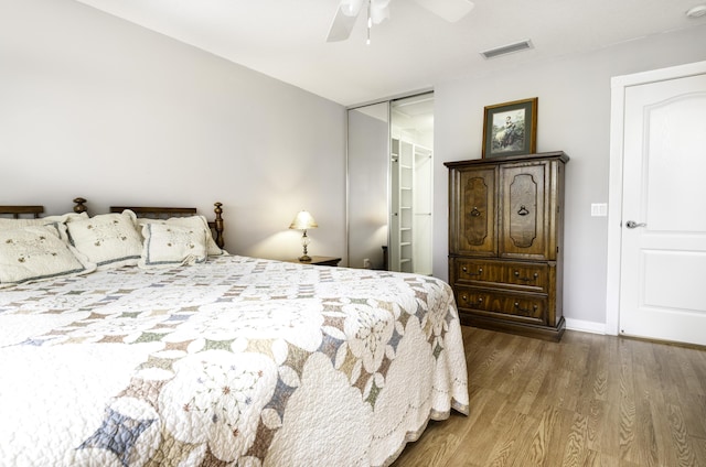 bedroom with ceiling fan, a spacious closet, hardwood / wood-style floors, and a closet