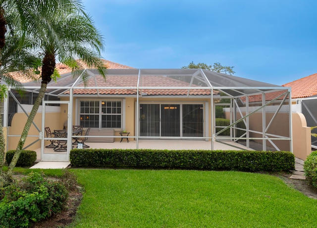 back of property with a yard and a lanai