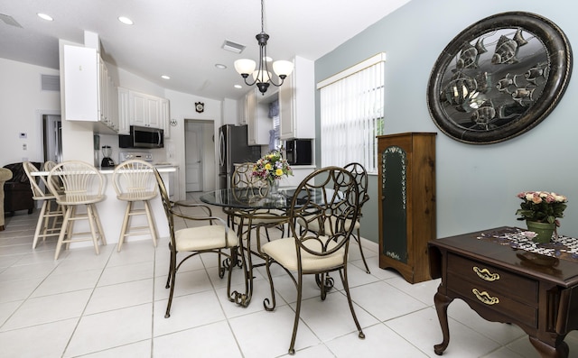 dining room with vaulted ceiling, light tile patterned floors, and a notable chandelier