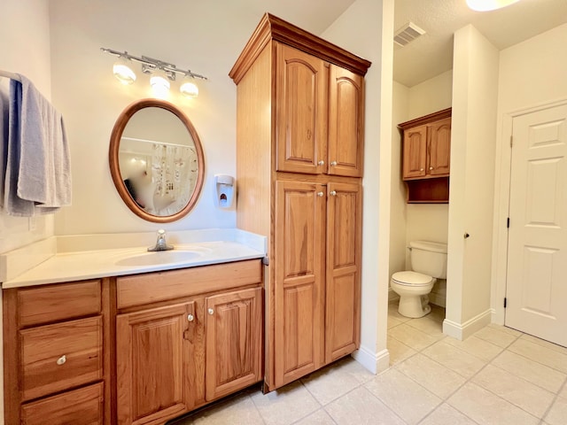 bathroom featuring tile patterned floors, toilet, and vanity