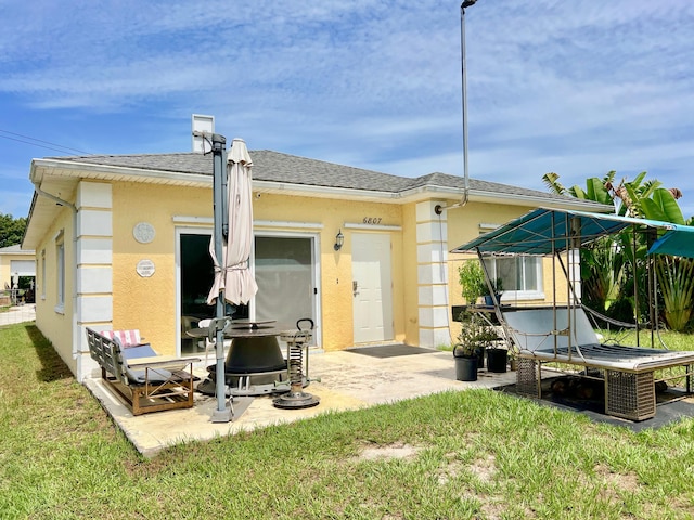 rear view of house with a patio and a lawn