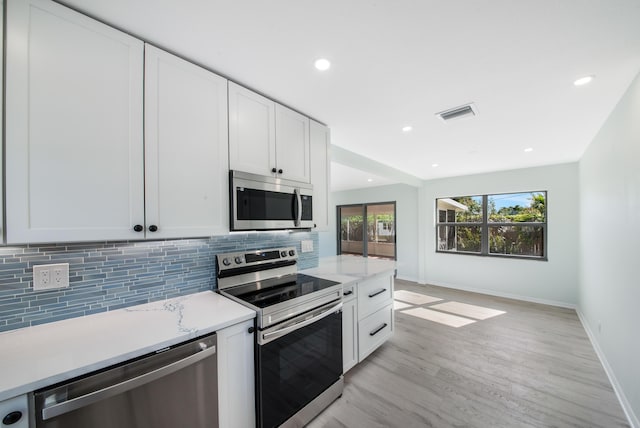 kitchen with white cabinets, stainless steel appliances, and light hardwood / wood-style floors