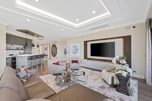 living room featuring ornamental molding, indoor bar, and hardwood / wood-style flooring