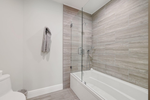 bathroom with bath / shower combo with glass door, wood-type flooring, and toilet