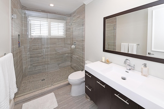 bathroom featuring vanity, toilet, hardwood / wood-style flooring, and a shower with shower door