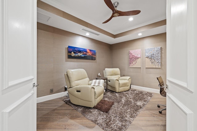 living area featuring wood-type flooring and ceiling fan