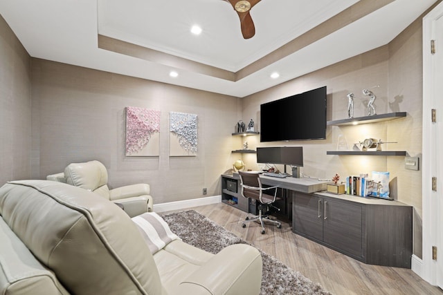 office space with light hardwood / wood-style floors, a tray ceiling, and ceiling fan