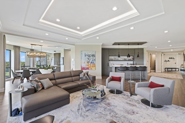 living room featuring ornamental molding, hardwood / wood-style flooring, and a raised ceiling