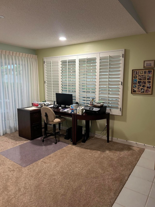 carpeted home office with a textured ceiling