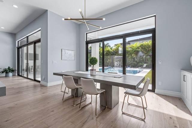 dining space featuring light hardwood / wood-style floors and an inviting chandelier