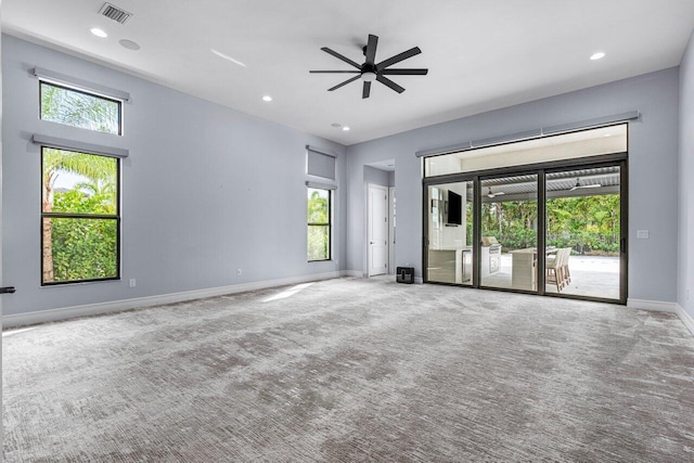 unfurnished room with carpet flooring, plenty of natural light, and ceiling fan