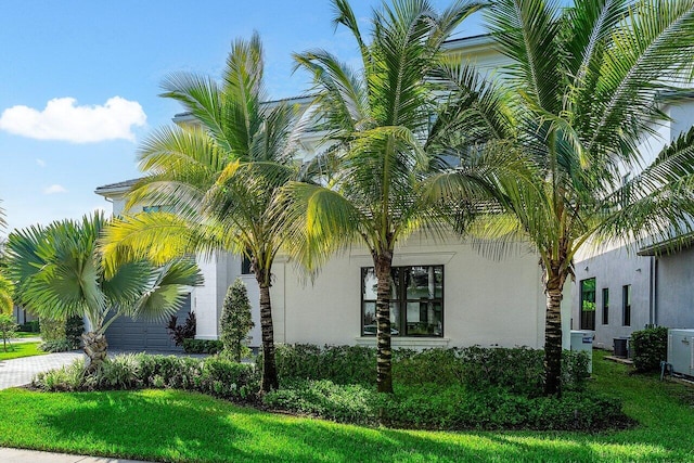 view of side of property with cooling unit and a lawn