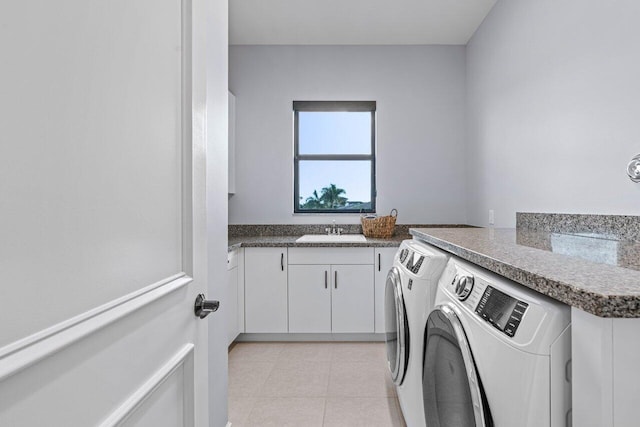 laundry area featuring cabinets, separate washer and dryer, and sink