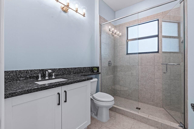 bathroom with tile patterned floors, vanity, toilet, and an enclosed shower