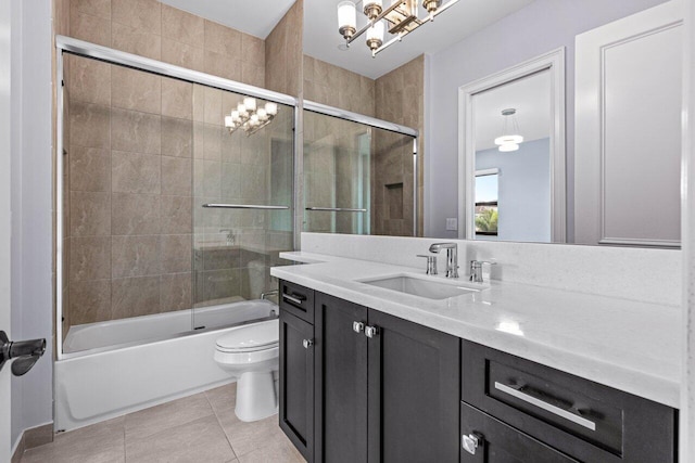 full bathroom with tile patterned floors, vanity, toilet, and bath / shower combo with glass door