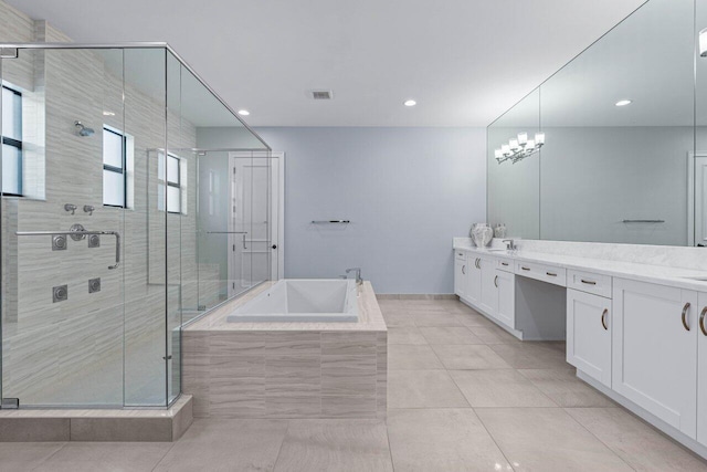 bathroom with tile patterned floors, a notable chandelier, independent shower and bath, and vanity