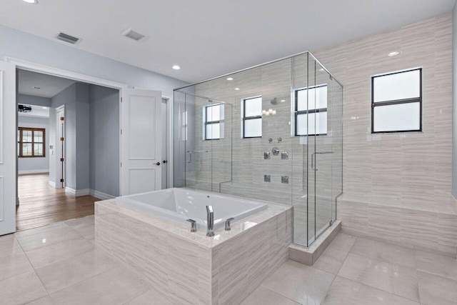 bathroom featuring plenty of natural light and independent shower and bath