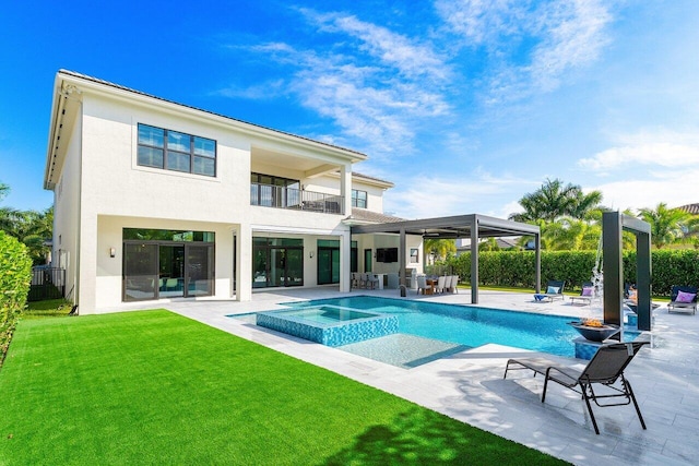 rear view of house with a yard, a patio area, a swimming pool with hot tub, and a balcony