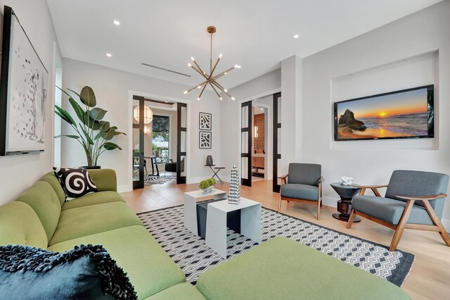 living room with a notable chandelier and light hardwood / wood-style flooring