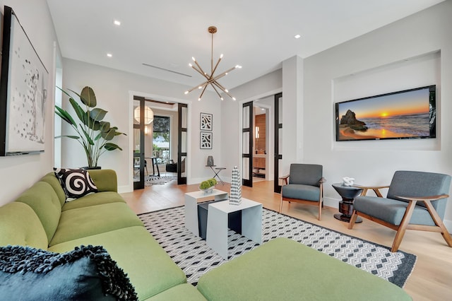 living area with a chandelier, recessed lighting, baseboards, and light wood finished floors