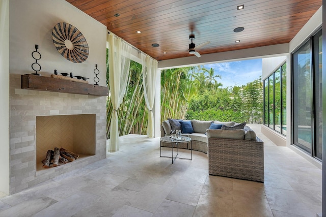 view of patio / terrace with ceiling fan and an outdoor living space with a fireplace