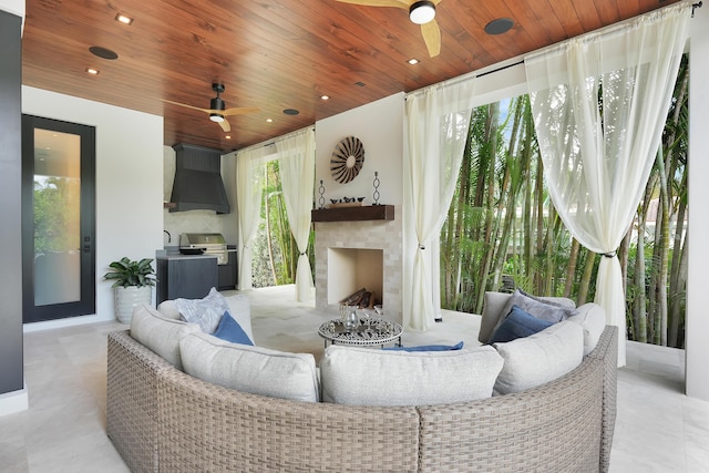 interior space featuring exterior fireplace, wood ceiling, and a ceiling fan