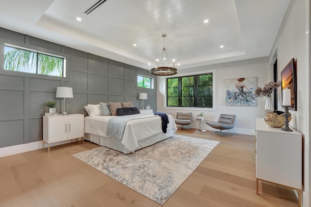 115 Gregory Rd, West Palm Beach, FL 33405 - bedroom with a decorative wall, a raised ceiling, light wood-style flooring, a chandelier, and recessed lighting