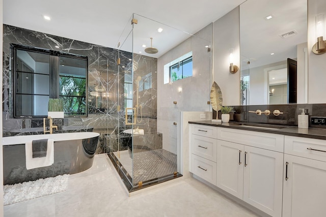 bathroom with backsplash, shower with separate bathtub, tile patterned floors, vanity, and tile walls