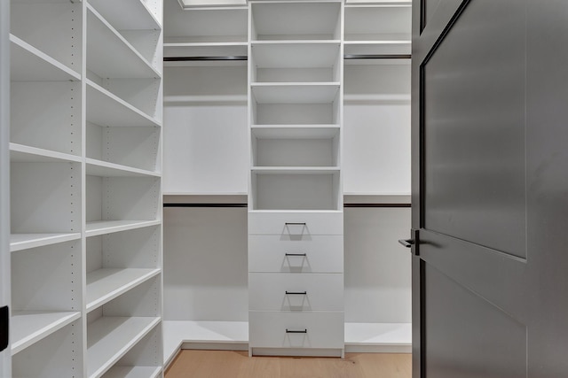 walk in closet with wood finished floors