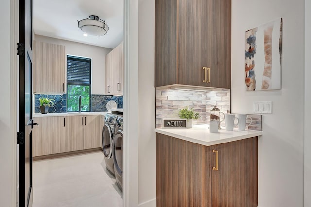 washroom with cabinet space, a sink, and independent washer and dryer