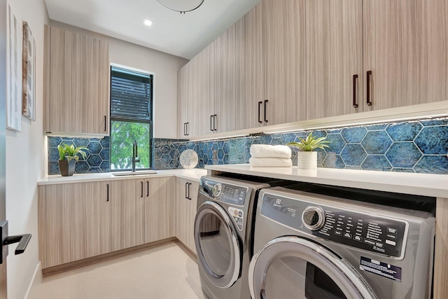 laundry room featuring cabinet space, a sink, and independent washer and dryer