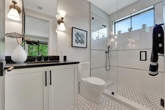 bathroom featuring toilet, a shower stall, visible vents, and vanity